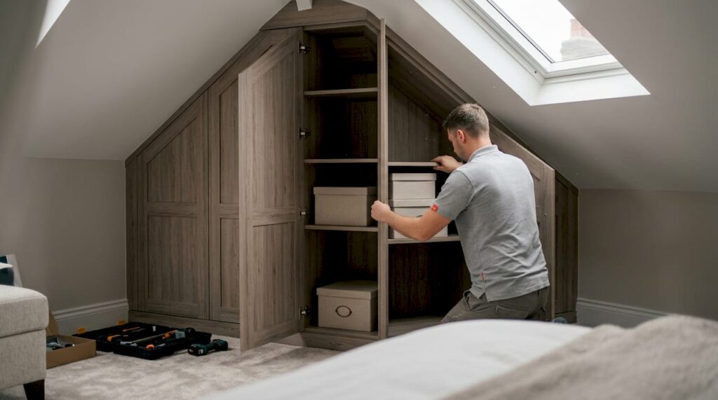 Fitter installing bespoke fitted wardrobe in London bedroom