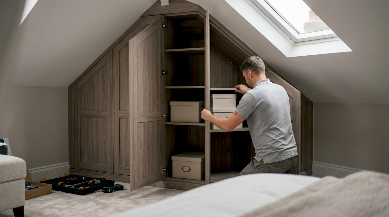 Fitter installing bespoke fitted wardrobe in London bedroom