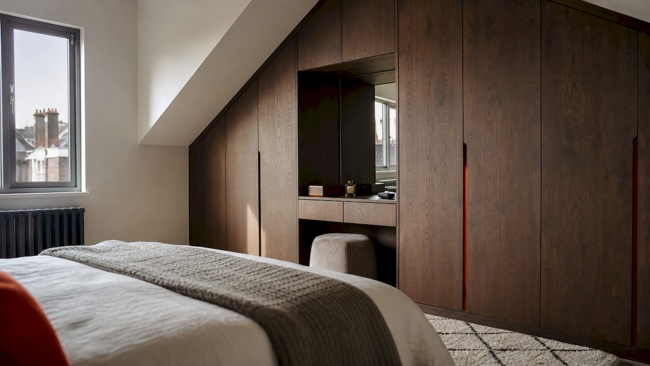 Bespoke fitted wood effect wardrobes in London bedroom