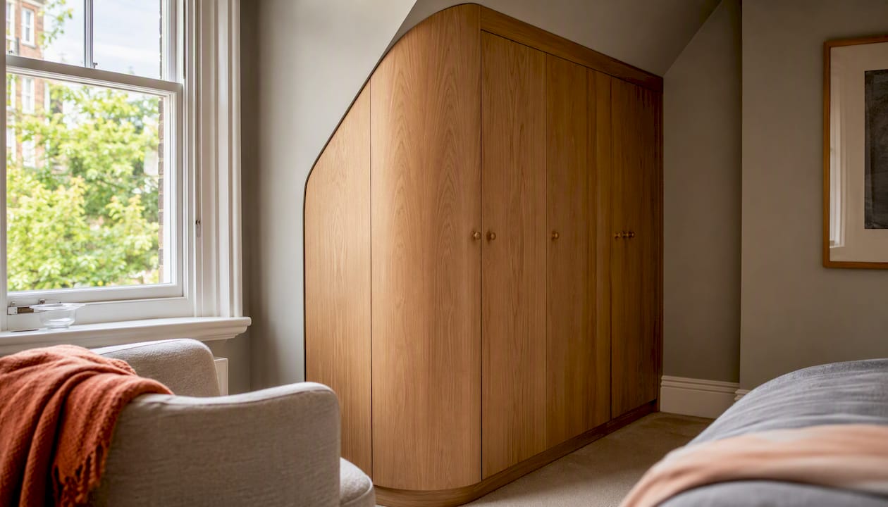 Custom fitted wardrobe under sloping ceiling in London