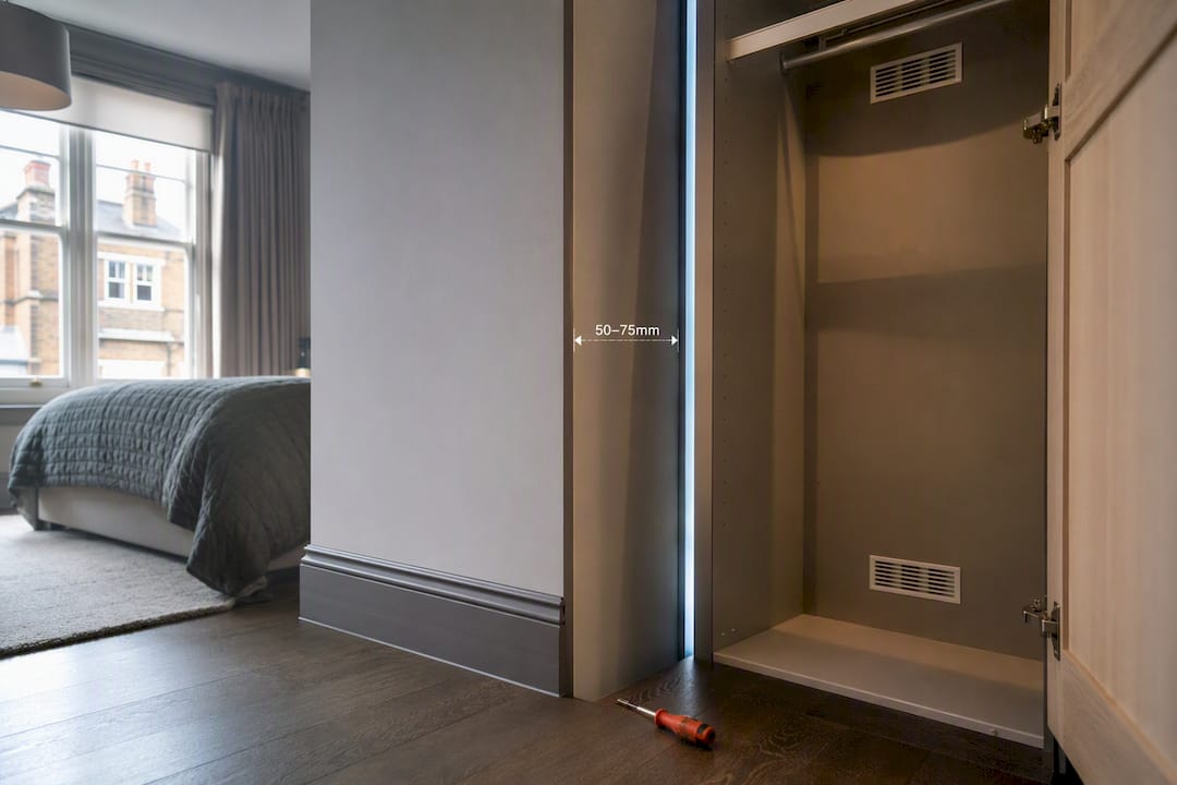 Wardrobe wall gap with ventilation grilles